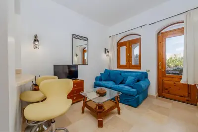 a living room with a blue couch and a table at Cozy Studio Ground floor in Upper Nubia in Hurghada