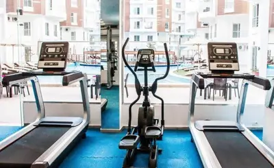 a gym with two treadying machines in front of a window at Hotel Room in Aqua Palms Hurghada in Hurghada