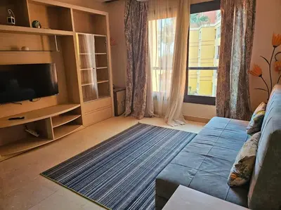 a living room with a couch and a television at Esplanada flat with free beach, no single men in Hurghada