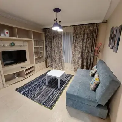 a living room with a blue couch and a table at Esplanada flat with free beach, no single men in Hurghada