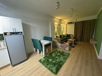 a living room with a couch and a table and a refrigerator at Luxurious heart flat in Hurghada