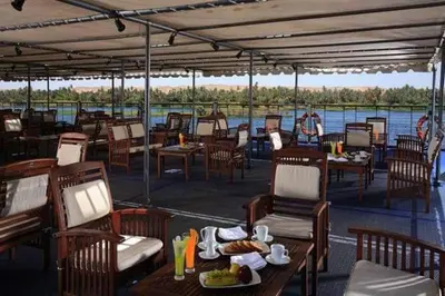 a restaurant on a boat with tables and chairs at Sofia Nile Cruise Luxor & Aswan in Luxor