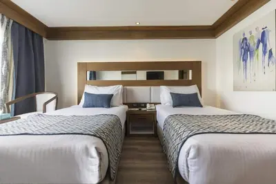 a hotel room with two beds and a desk at Sofia Nile Cruise Luxor & Aswan in Luxor