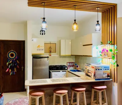 a kitchen with a counter with bar stools in it at Makadi Heights lovely flat in Hurghada
