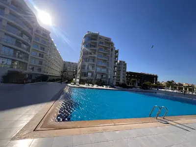 a swimming pool with two tall buildings in the background at Scanddic Resort Hurghada in Hurghada
