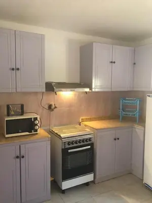 a kitchen with white cabinets and a stove top oven at Villa Sara Touristic Center in Hurghada