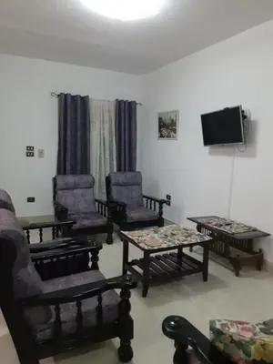 a living room with chairs and a flat screen tv at Villa Sara Touristic Center in Hurghada
