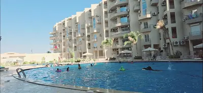 a group of people in a swimming pool next to a building at princess apartments in Hurghada