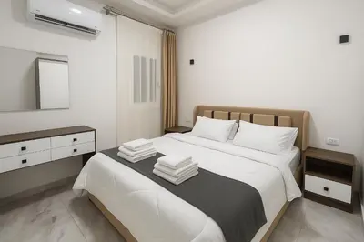 a bedroom with a bed with white sheets and a mirror at Selena Bay Luxury Sea View 1BR Apartment, Private Beach and Pool in Hurghada