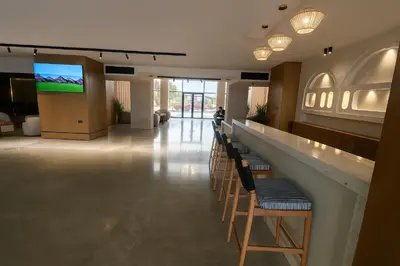 a lobby with chairs and a bar with a flat screen tv at Selena Bay Luxury Sea View 1BR Apartment, Private Beach and Pool in Hurghada