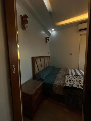 a small bedroom with a bed and a chair at Super Elite apartment - Aswan city center apartments in Aswan