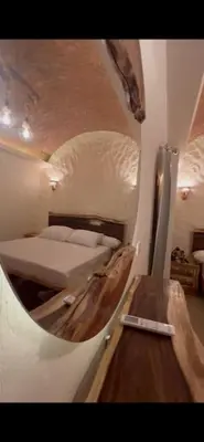 a small room with a bed and a mirror at Klimatyczny apartament na dachu w sercu Hurghady in Hurghada