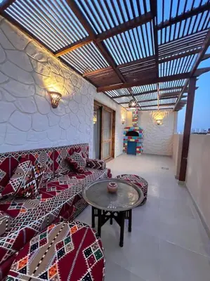 a living room with couches and a table in a room at Klimatyczny apartament na dachu w sercu Hurghady in Hurghada