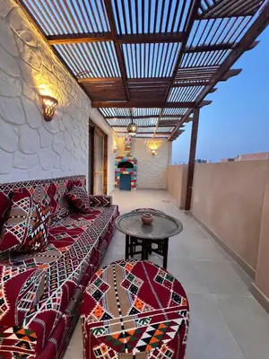 a living room with a couch and a table at Klimatyczny apartament na dachu w sercu Hurghady in Hurghada