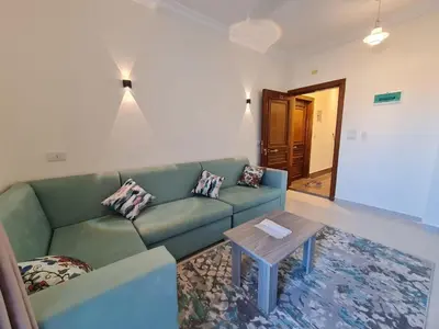 a living room with a green couch and a table at Star house apartments in Hurghada