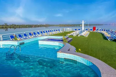 a swimming pool with lounge chairs and a cross in the water at Nile Cruise 3 Nights Aswan to Luxor Sightseeing Included in Nag` el-Ramla