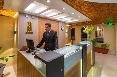 a man standing at a desk in an office at Nile Cruise 3 Nights Aswan to Luxor Sightseeing Included in Nag` el-Ramla