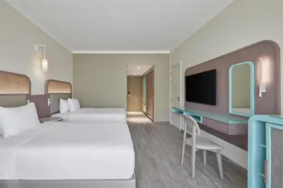 a hotel room with two beds and a desk at Doubletree By Hilton Mangroovy El Gouna Resort in Hurghada
