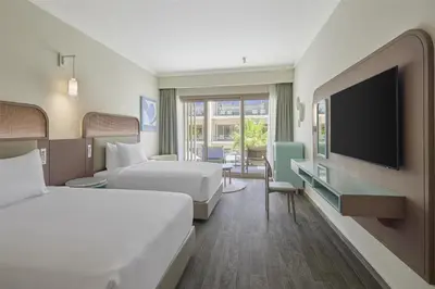 a hotel room with two beds and a flat screen tv at Doubletree By Hilton Mangroovy El Gouna Resort in Hurghada