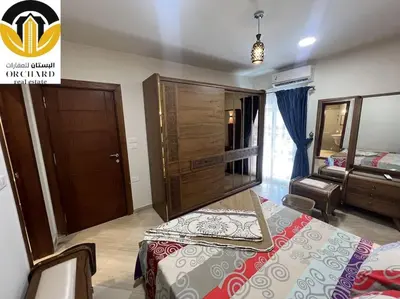 a bedroom with a bed and a wooden cabinet at CAMUS 243, Princess Resort in Hurghada