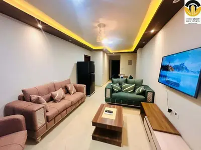 a living room with couches and a flat screen tv at CAMUS 243, Princess Resort in Hurghada