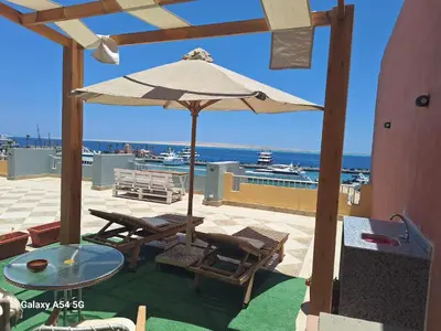 a patio with a table and chairs and an umbrella at comfort marine 2 in Hurghada
