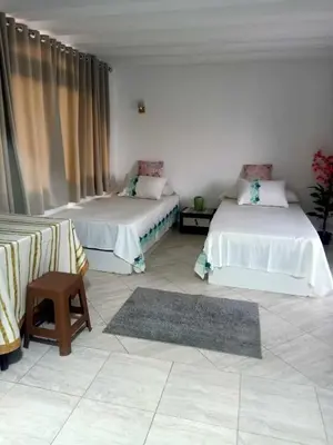 a room with two beds and a chair and a rug at comfort marine 2 in Hurghada