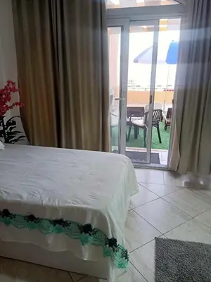 a bedroom with a bed and a view of a patio at comfort marine 2 in Hurghada