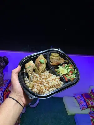 a person holding a tray of food with rice and vegetables at Mo Asha in Safaga