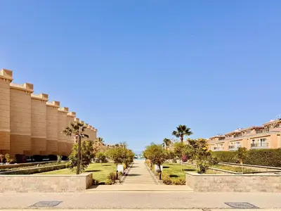 a street in a city with palm trees and buildings at Comfy Studio, Pools, private Beach at peaceful Resort in Hurghada