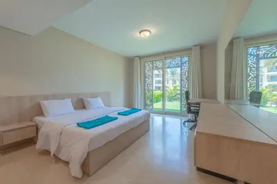 a bedroom with a bed with two blue towels on it at Elegant apartment with pool and beach access in Hurghada