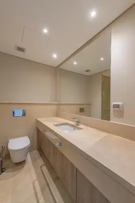 a bathroom with a sink and a toilet and a mirror at Elegant apartment with pool and beach access in Hurghada