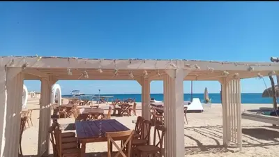 a table and chairs on a beach with the ocean at Chalet private beach and pool view in Hurghada