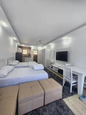 a bedroom with two beds and a desk and a tv at Chalet private beach and pool view in Hurghada
