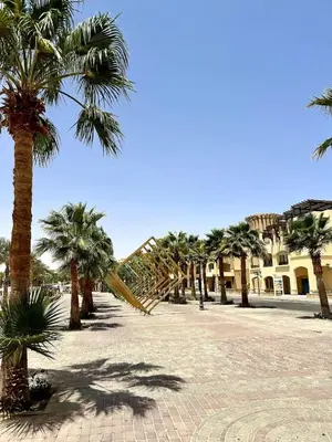 a row of palm trees in a courtyard at El Andalous Sea View Apartment Sahl Hasheesh in Hurghada