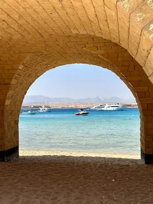 a view of the water from under a stone bridge at El Andalous Sea View Apartment Sahl Hasheesh in Hurghada