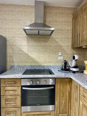 a kitchen with a stove and a hood at El Andalous Sea View Apartment Sahl Hasheesh in Hurghada