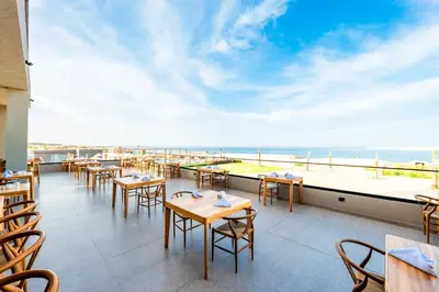 a restaurant with tables and chairs and a view of the ocean at Sentido Naga Bay - Adults friendly in Hurghada