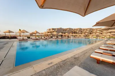 a large swimming pool with chairs and umbrellas at Sentido Naga Bay - Adults friendly in Hurghada