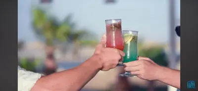 two people holding up drinks in their hands at Hurghada-Scandic Resort-The Diamond Of Scandic Apartment -Sea veiw&Sandy Beach Just Downstairs in Hurghada