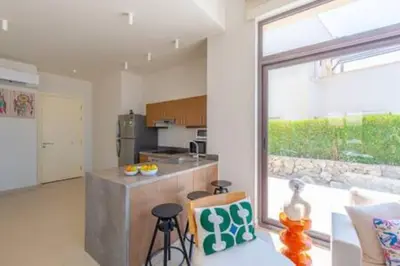 a kitchen with a counter and some chairs in a room at The Lakefront Villa 4BR at Cyan ElGouna in Hurghada