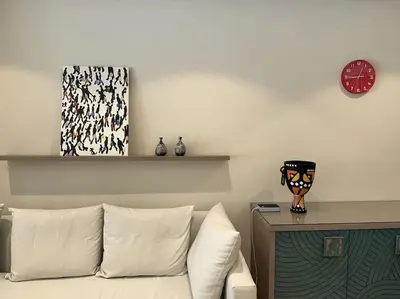 a living room with a couch and a clock on the wall at Marvelous 2BR - Free Beach Access and Pool Access In Mangroovy in Hurghada
