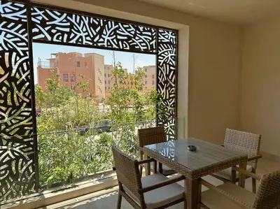 a dining room with a table and a large window at Marvelous 2BR - Free Beach Access and Pool Access In Mangroovy in Hurghada
