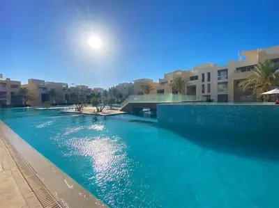 a body of water with a bridge and buildings at Marvelous 2BR - Free Beach Access and Pool Access In Mangroovy in Hurghada