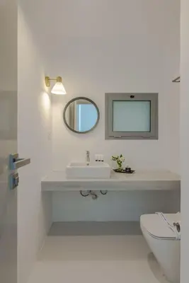 a white bathroom with a sink and a mirror at Elegant 3BR on Swan Lake Crystal Lagoon at Elgouna Families Only in Hurghada