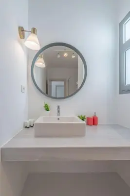 a white bathroom with a sink and a mirror at Elegant 3BR on Swan Lake Crystal Lagoon at Elgouna Families Only in Hurghada