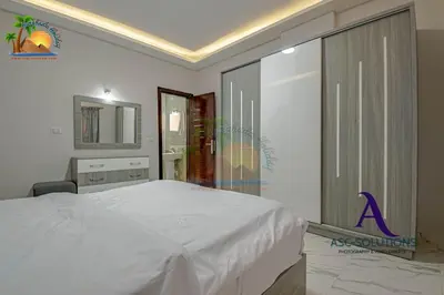 a bedroom with a white bed and a mirror at The Awesome 3-Bedroom Apartment & 2 bathroom in Al-Ahyaa Hurghada in Hurghada