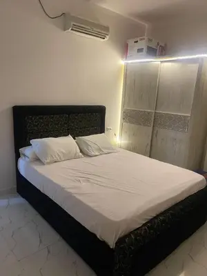 a bed with white sheets and pillows in a room at استديو فندقى على البحر كمبوند بريستيجا اول طلعة فلفله الشيراتون in Hurghada