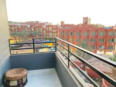 a balcony with a stool and a view of a city at استديو فندقى على البحر كمبوند بريستيجا اول طلعة فلفله الشيراتون in Hurghada
