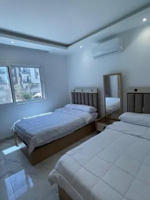 a bedroom with two beds and two windows at Fanadir Bay in Hurghada